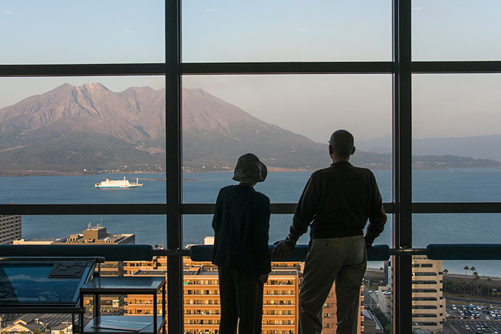 ４月１２日のスナップ。県庁の展望台から桜島を眺める両親
