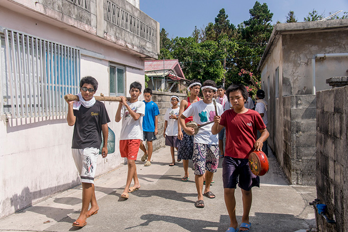 家々をまわって神酒（泡盛）を集める子供たち
